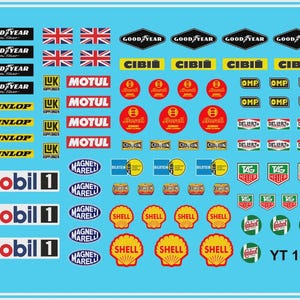 May include: A sheet of water slide decals for model cars, featuring various racing sponsor logos and flags. Logos include Goodyear, Mobil 1, Shell, and others. The scale is 1:24.