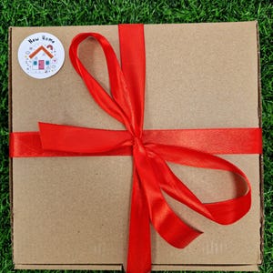 red ribbon around box with a new home sticker