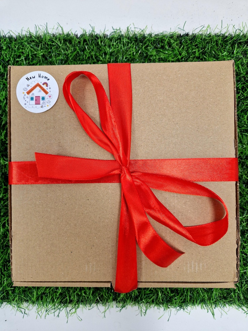 red ribbon around box with a new home sticker