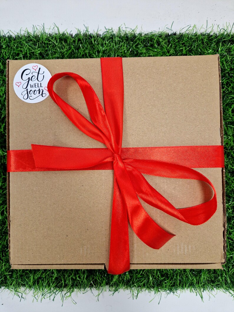 red ribbon around box with a get well soon sticker