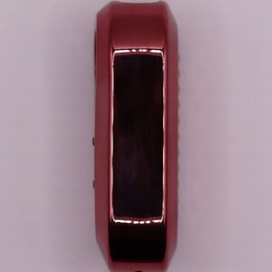 Puede incluir: Un llavero de coche rojo con una pantalla rectangular negra.