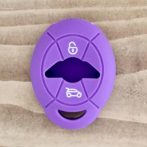 Può includere: Copri chiave in silicone viola con icone bianche per il blocco, il bagagliaio e l'auto.