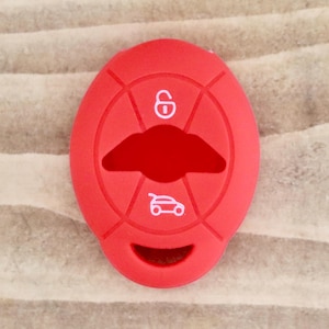 May include: Red silicone key fob cover with white icons of a lock, a car, and a boot.