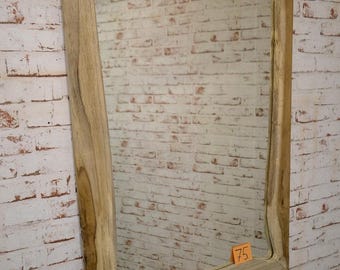 Könnte beinhalten: Rechteckiger Holzspiegel mit einem Naturholzrahmen. Der Rahmen hat eine einzigartige, leicht unregelmäßige Form. Der Spiegel hängt an einer weißen Backsteinmauer. Ein kleines orangefarbenes Preisschild mit der Nummer 75 ist sichtbar.