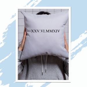 Könnte beinhalten: Ein graues Kissen mit dem aufgedruckten Text "XXV.VI.MMXIV".