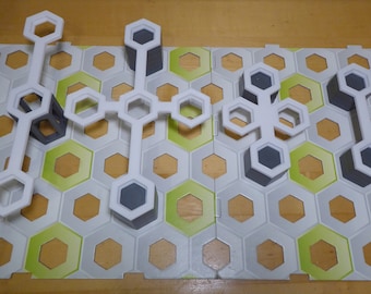 Puede incluir: Un tablero de juego de plástico blanco con un patrón de panal. El tablero tiene varias piezas de plástico blanco con agujeros que se pueden conectar para formar diferentes formas. Las piezas están conectadas para formar un puente a través del tablero.
