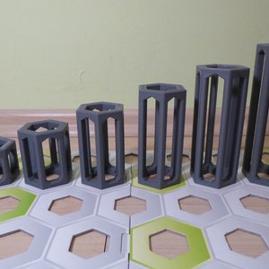 Puede incluir: Seis contenedores hexagonales grises, impresos en 3D, con la parte superior abierta, de diferentes tamaños. Los contenedores están dispuestos en una fila del más pequeño al más grande.