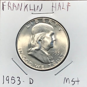 May include: A silver 1953-D Franklin half dollar coin with the inscription "LIBERTY" above the profile of Benjamin Franklin and "IN GOD WE TRUST" below. The coin is in a plastic coin holder with the text "FRANKLIN HALF" and "MS+" written on it.