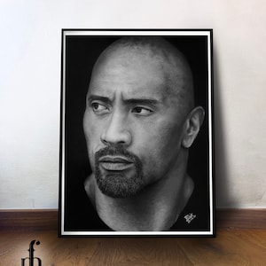 Può includere: Disegno a matita in bianco e nero del volto di Dwayne "The Rock" Johnson. Il disegno è incorniciato in una cornice nera e si trova su un pavimento di legno.