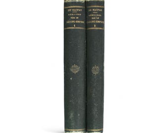 Könnte beinhalten: Zwei antike Bücher mit dunkelgrünen Einbänden. Die Buchrücken weisen goldene Schrift und dekorative Embleme auf. Die Titel lauten "DE MAUPAS MEMOIRES SUR LE SECOND EMPIRE" mit den Bandnummern 1 und 2.