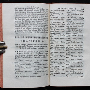 May include: An open book with yellowed pages and a brown leather cover. The book is titled "Esdras" and the text is in French. The book is open to Chapter 10 and includes a list of names.