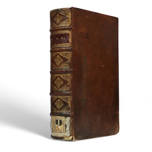 May include: A brown leather-bound book with gold detailing and a title on the spine that reads "A.O.M."