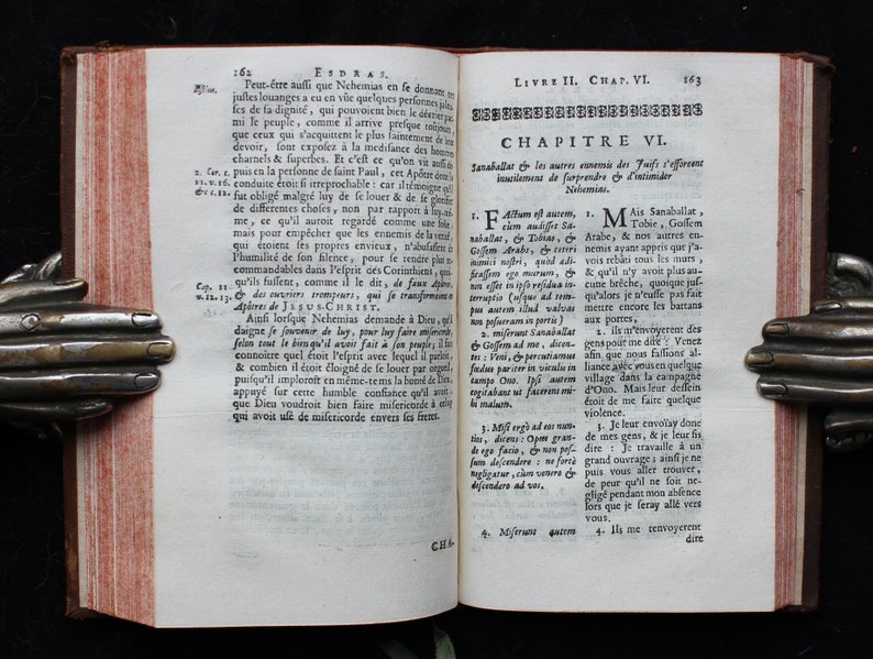 May include: An open book with yellowed pages and a red spine. The book is open to a page with text in French, titled "Chapitre VI." The text is about the history of the Jewish people.