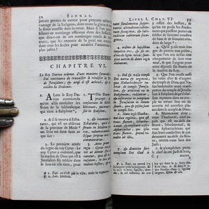 May include: A page from an antique book with text in French. The text is about the rebuilding of the temple in Jerusalem. The page is yellowed with age and has a worn, aged appearance.
