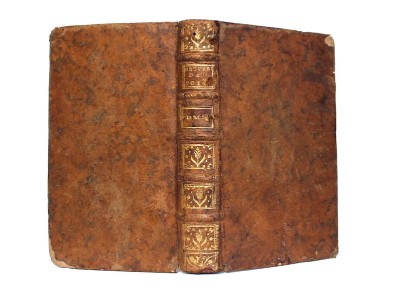 May include: A brown leather-bound book with gold lettering on the spine. The title reads "OEUVRES DE POESIE TOM. I."