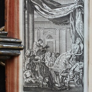 May include: A black and white engraving depicting a group of people in a room. A woman is reclining on a chair, while others are seated or standing around her. The engraving is titled "Leur Corps panche, tantot d'un c&ocirc;t&eacute; et tantot de l'autre &agrave; proportion du degr&eacute; d'efficace des vers ou de la prose."