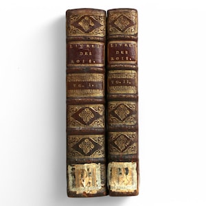May include: Two antique leather-bound books with gold lettering and decorative patterns. The books are titled "Livre des Rois" and are labeled "Tom. I." and "Tom. II."