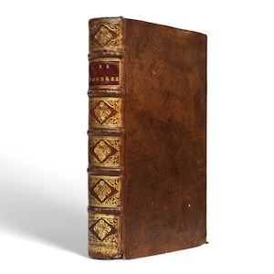 May include: A brown leather-bound book with gold accents and the text "LES OEUVRES" on the spine.