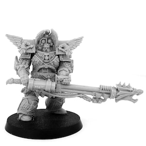 Puede incluir: Figura en miniatura gris detallada de un guerrero con armadura ornamentada, sosteniendo un arma grande. La figura está sobre una base negra. La armadura presenta detalles alados y diseños intrincados, con un casco y un arma con cabeza de dragón.