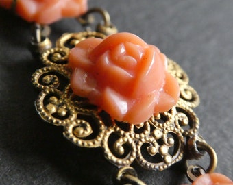 Vintage 1930s Art Deco early plastic rose and gold tone filigree panel bracelet - coral coloured moulded flowers