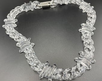 Collar grueso de plástico transparente estilo lucite/plexiglás con diseño vintage de alambre de púas y cierre tipo mosquetón en tono plateado.