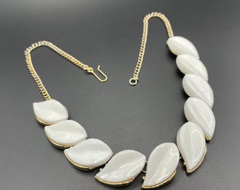 Collar vintage de plástico lucita blanco con diseño floral o de hojas en tono dorado, estilo Trifari o Coro de vidrio vertido pero sin firma.
