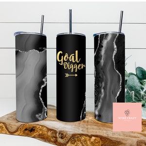 May include: Three stainless steel tumblers with black and white agate designs. The center tumbler has the text "Goal Digger" in gold lettering with a gold arrow.