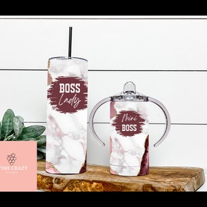 May include: Two stainless steel tumblers with a marble and pink agate design. The larger tumbler has the text "Boss Lady" on it. The smaller tumbler has the text "Mini Boss" on it.