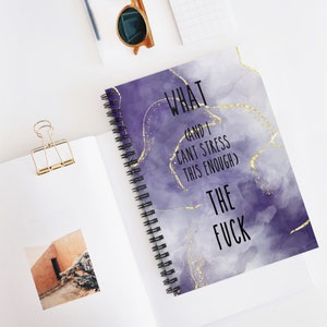 May include: Purple and gold spiral notebook with the text "What (and I can't stress this enough) The Fuck" on the cover.