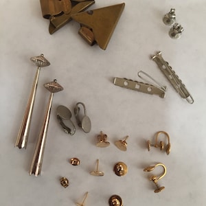 May include: Assortment of gold and silver earring findings, including post backs, clip-on backs, and earring wires. There are also two gold-toned hair clips.
