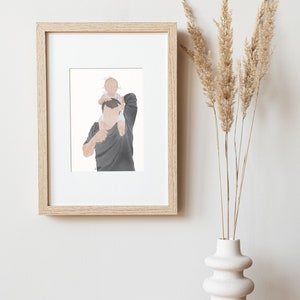 K&ouml;nnte beinhalten: Eine gerahmte Illustration von einem Vater und einem Kind. Der Vater tr&auml;gt ein dunkelgraues Hemd und das Kind tr&auml;gt ein wei&szlig;es und rosa Hemd. Die Illustration ist in einem hellen Holzrahmen.