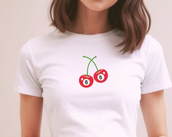 May include: White crop top with a red cherry design. The cherries have a green stem and a white number 8 on each.