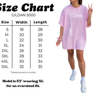 Op de afbeelding: Een Gildan 5000 maattabel voor een lichtroze t-shirt. De tabel toont de maten S tot en met 5XL met bijbehorende breedte- en lengtematen in inches. Een diagram op het t-shirt geeft aan waar de breedte en lengte worden gemeten. De tekst luidt: Model is 5'2" wearing XL for an oversized fit.