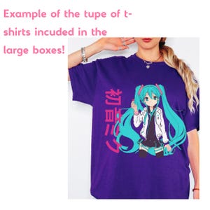 Op de afbeelding: Een paars t-shirt met korte mouwen en een afbeelding van een anime-personage met lang groenblauw haar, gekleed in een wit jasje en een zwarte rok. Het ontwerp bevat de roze Japanse tekst 初音ミク verticaal aan de linkerkant.