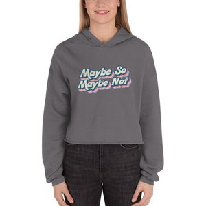 Może przedstawiać: Szara, krótka bluza z kapturem, długimi rękawami i sznurkiem do regulacji kaptura. Bluza ma nadrukowany retro-grafikę z napisem "Maybe So Maybe Not" w kolorze niebieskim, różowym i żółtym.