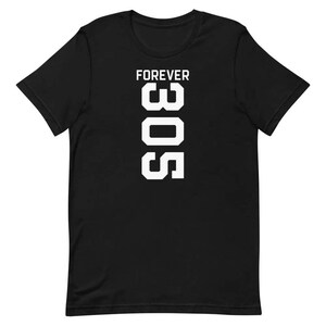 Puede incluir: Camiseta negra con la inscripción blanca "FOREVER 305" impresa verticalmente. Esta camiseta de cuello redondo y manga corta es ideal para un look casual. El diseño es simple y audaz, con una tipografía clara y legible.