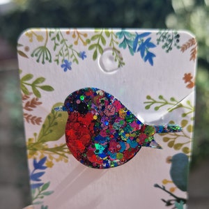 Peut inclure: Une broche en forme de rouge-gorge en paillettes rouges, bleues et vertes. Le rouge-gorge est un symbole populaire du printemps et des nouveaux d&eacute;parts.