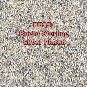 Puede incluir: Primer plano de una gran cantidad de pequeñas cuentas plateadas. Las cuentas son redondas y tienen un acabado brillante. El texto "DB551 Bright Sterling Silver Plated" está superpuesto en la imagen.
