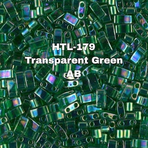 Op de afbeelding: Close-up van transparante groene AB-afwerking kralen. De kralen zijn rechthoekig met afgeronde randen en hebben een iriserende glans. De tekst "HTL-179 Transparent Green AB" is in het wit zichtbaar. Geschikt voor het maken van sieraden en knutselen.