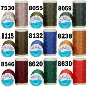 May include: Assortment of 10 spools of thread in various colors, including beige, green, blue, brown, red, and dark green. Each spool is labeled with the brand name "mez" and the text "Nylbond 60m".