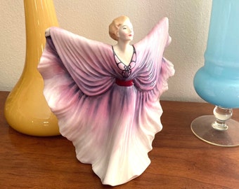 Gorgeous Vintage hand painted Royal Doulton Isadora Figurine with beautiful flowing purple dress draped in modern contemporary elegance .