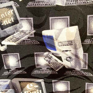 May include: A dark green necktie with a repeating pattern of computer monitors, keyboards, and the words "internet" and "e-mail" in white. The computer graphics are in shades of gray and white.