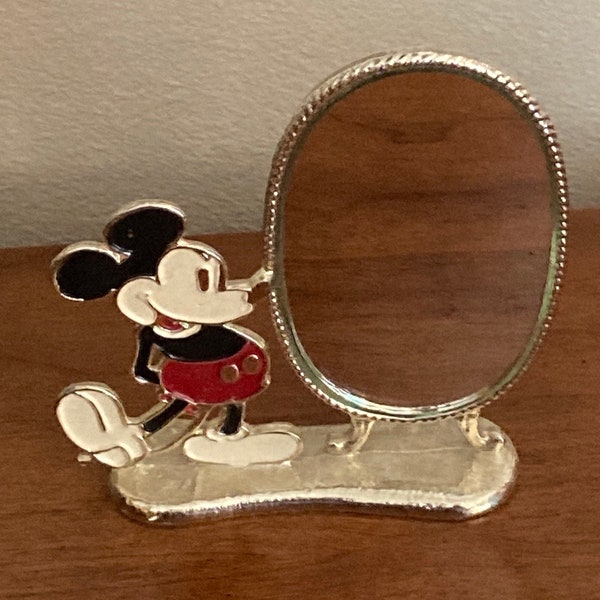 1970s Walt Disney productions sliver cast metal oval mirror with enameled classic Mickey Mouse on a pedestal base. This is a small piece.