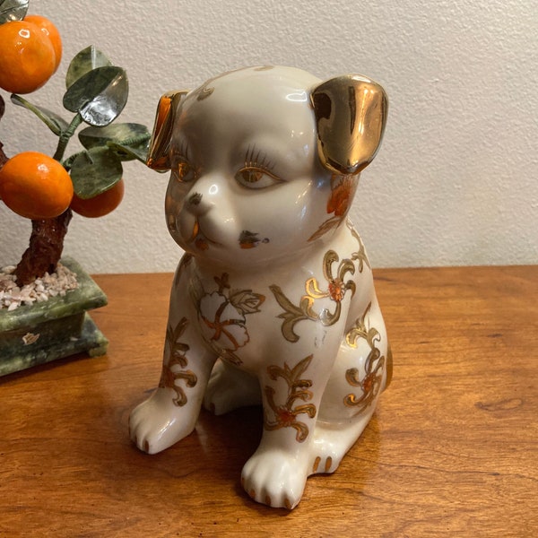 Vintage sitting Japanese hand painted ceramic dog figurine or statue with liquid gold Moriage accents and orange flowers. Beautiful