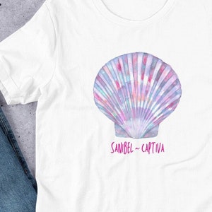 Peut inclure: T-shirt blanc avec un motif de coquillage aquarelle et le texte "Sanibel - Captiva" en rose.