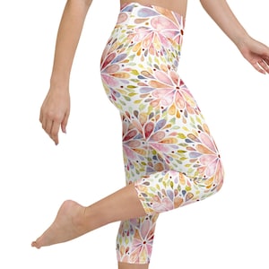 May include: White capri leggings with a colorful watercolor floral pattern. The pattern features shades of pink, blue, green, and yellow.