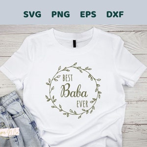 May include: White t-shirt with a green wreath design that says "Best Baba Ever".