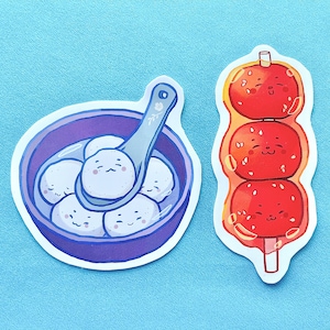 May include: Two stickers featuring cartoon food illustrations. One shows a purple bowl with white dumplings and a spoon. The other depicts three red, smiling, skewered balls. Both stickers have a white border and are on a light blue background.
