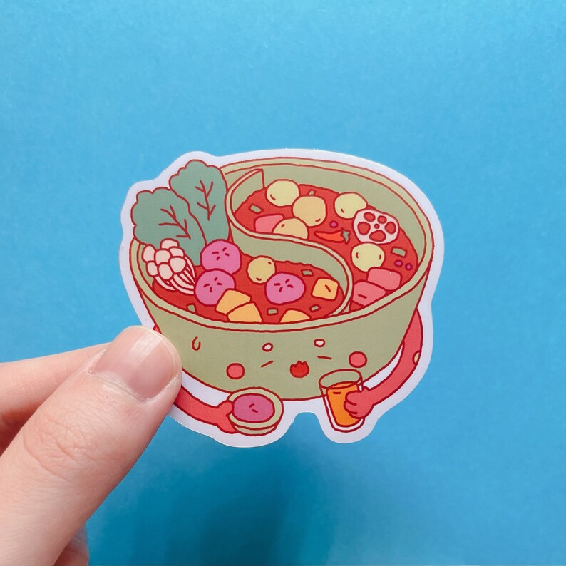 May include: A green cartoon hot pot with a smiling face, holding a small orange juice glass and a small bowl with a red sauce inside. The hot pot is filled with red broth and various ingredients, including vegetables and meat.