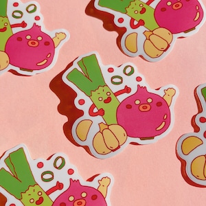 May include: Three cartoon stickers featuring a green onion, a red onion, and a garlic clove. Each sticker has a white background and features a cartoon character with a smiling face. The stickers are on a pink background.